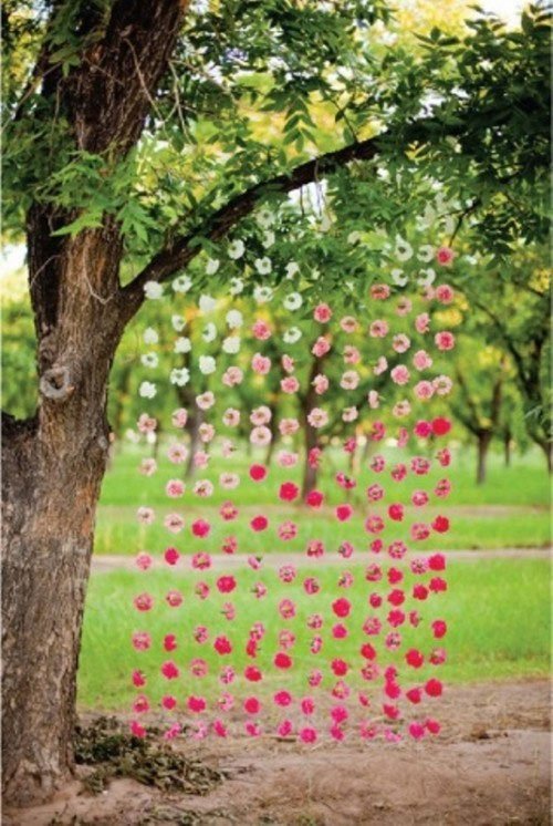 decoration reception de mariage originale jardin rideau de guirlandes de fleurs roses et violettes sur fil de nylon suspendues a un arblre